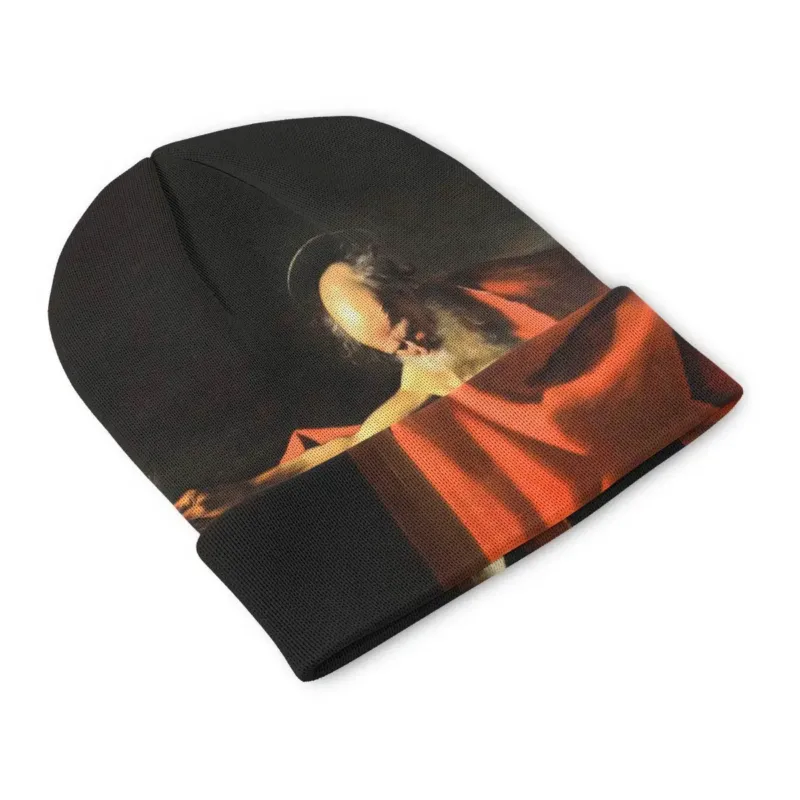 Front view of the Saint Jerome Writing beanie with a pale skull and writing hand emerging from darkness beside the red-draped figure.