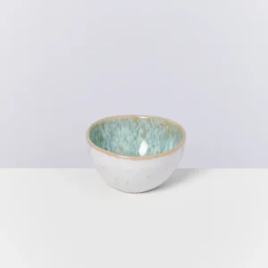Keramikschale mit weiß-blauer Glasur auf weißem Hintergrund.